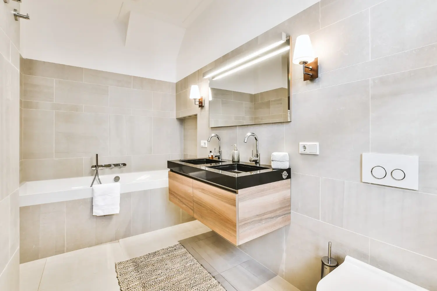 Completed bathroom remodel with black counter vanity and bathtub