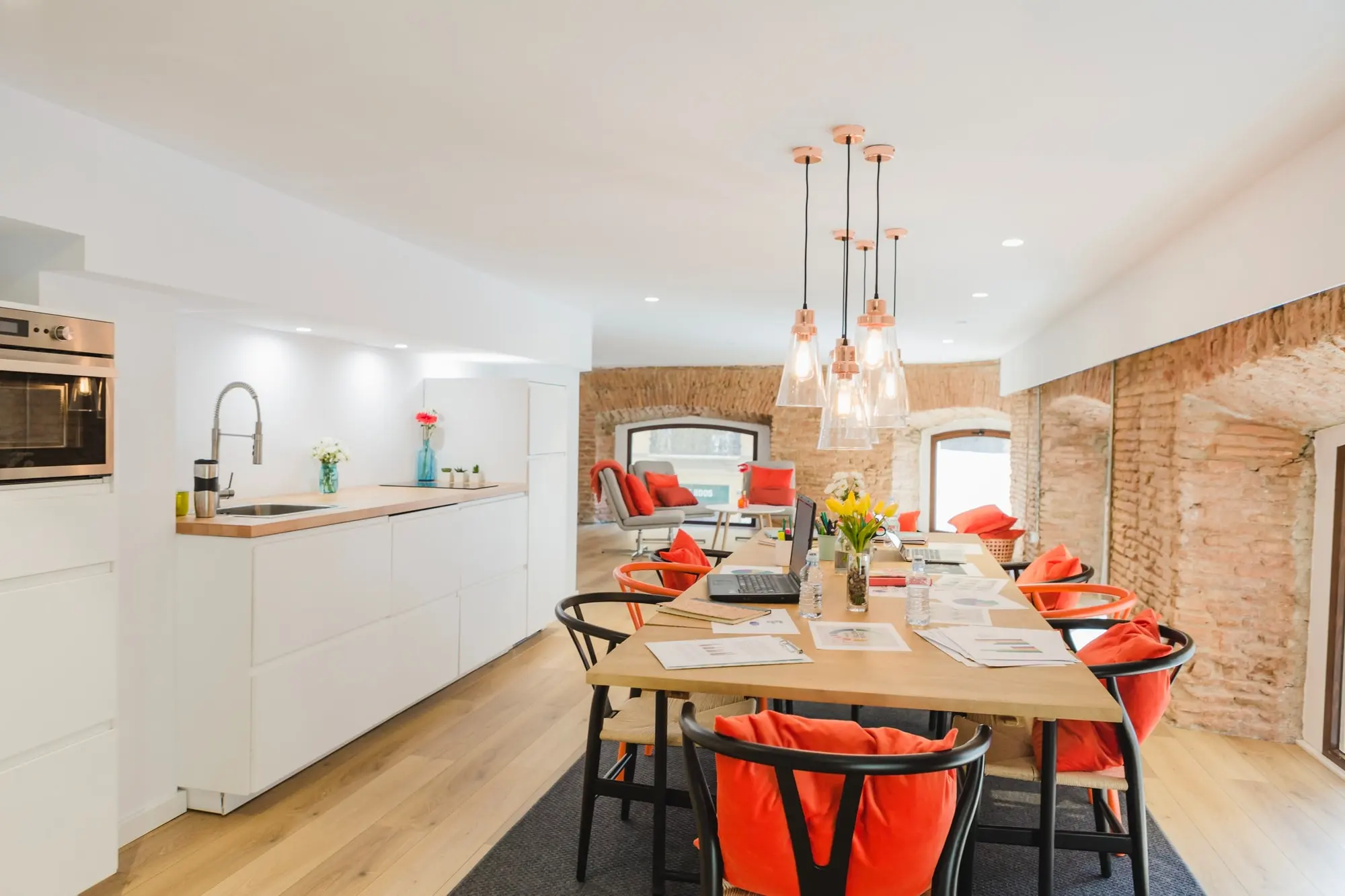 Completed white kitchen remodel with dining table and brick accent wall